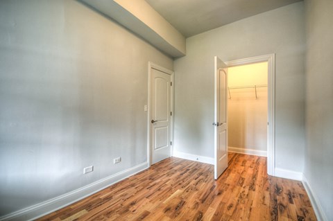 an empty room with wood floors and white walls