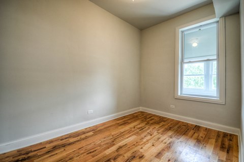 an empty room with wooden floors and a window