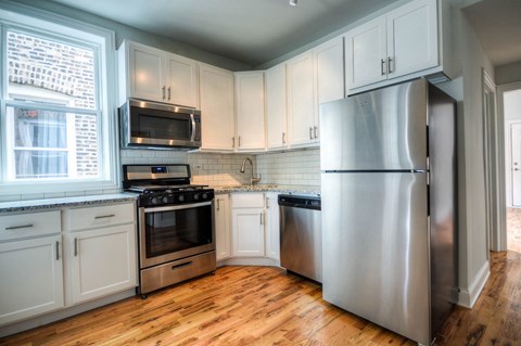 a kitchen with stainless steel appliances and white cabinets