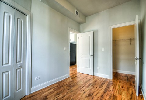 an empty living room with wood floors and a closet
