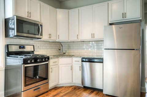 a kitchen with stainless steel appliances and white cabinets