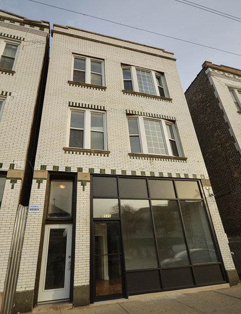 a white brick building with a large glass door