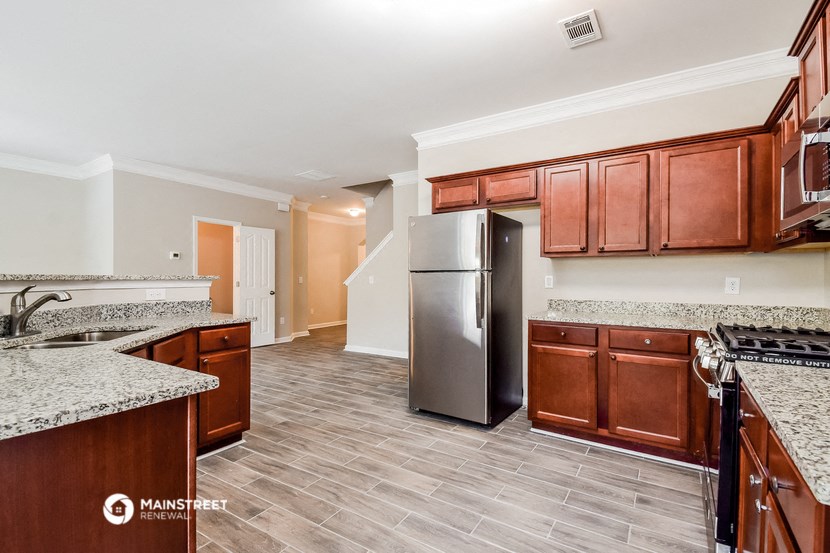 a kitchen with wooden cabinets and a stainless steel refrigerator