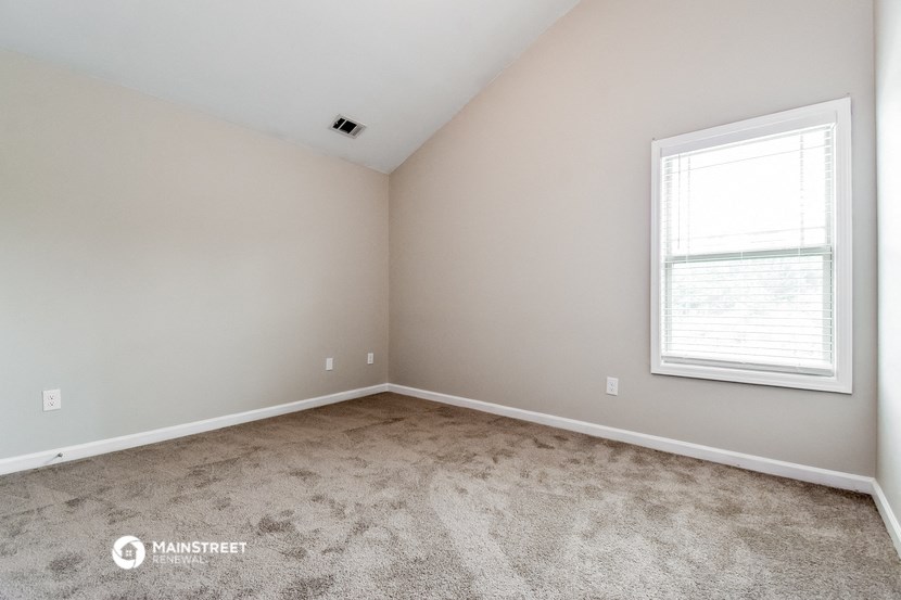 the upstairs bedroom with carpet and a window