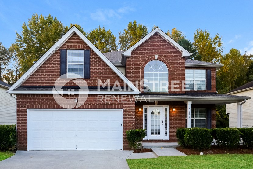 a red brick house with a white garage door