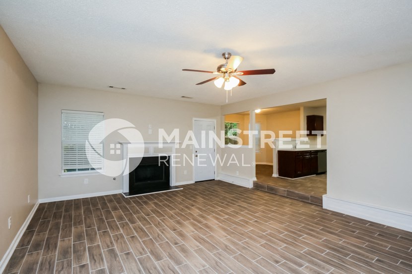 a living room with a ceiling fan and a tile floor