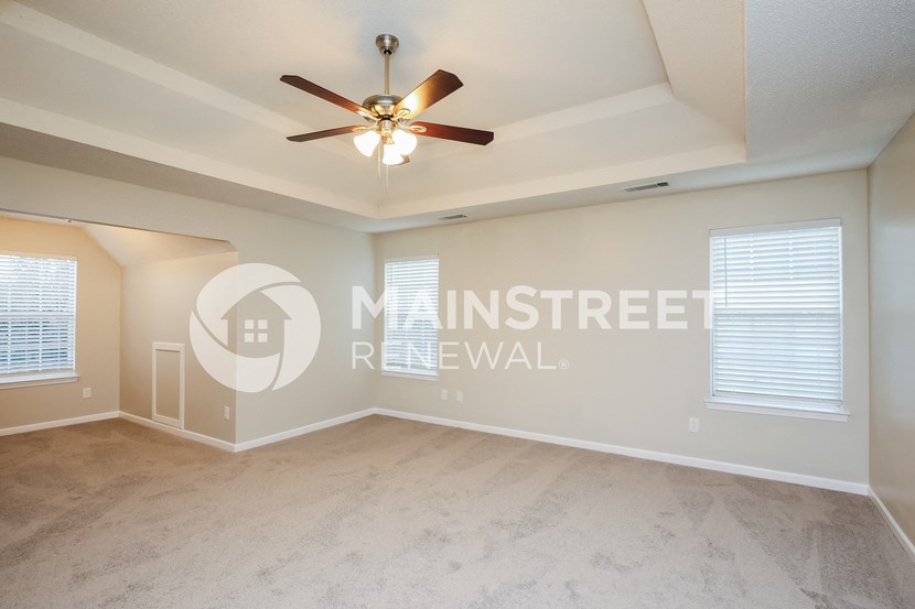 a living room with a ceiling fan and a marble floor