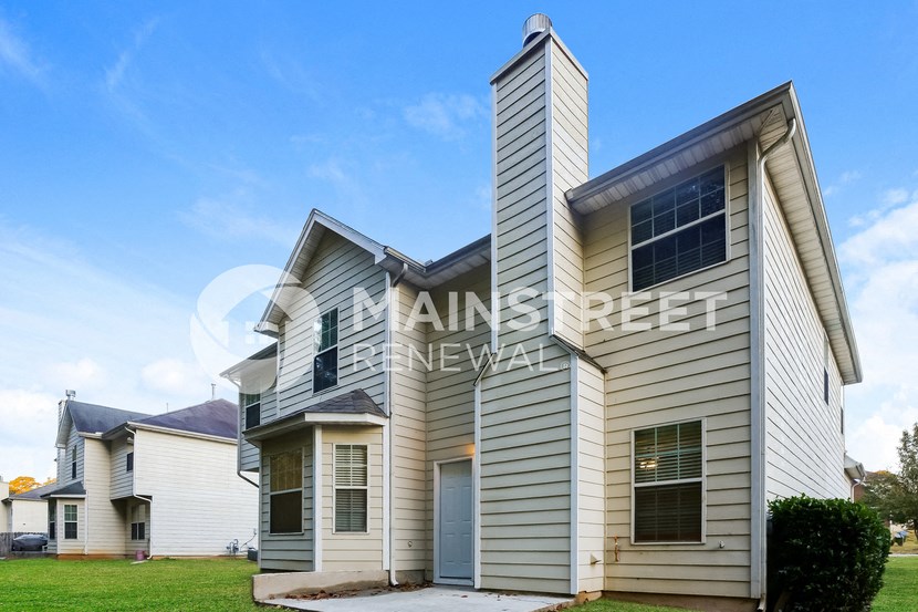 a white and with windows and a garage