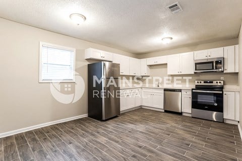 a kitchen with white cabinets and stainless steel appliances