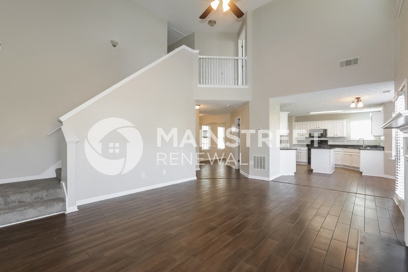a large living room with hardwood floors and a staircase