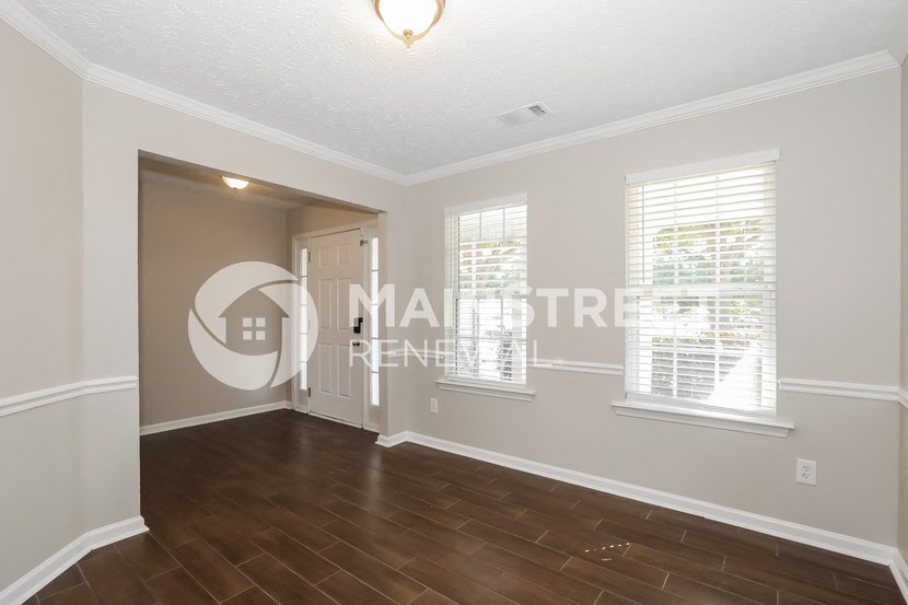 a living room with a hard wood floor and a white door