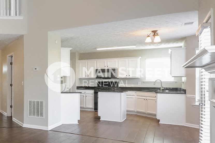 a renovated kitchen with white cabinets and a black counter top