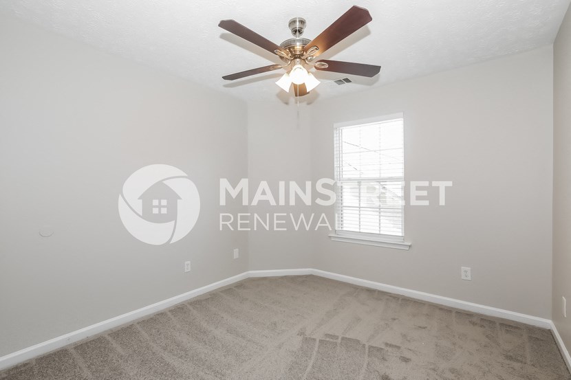 a bedroom with a ceiling fan and a window