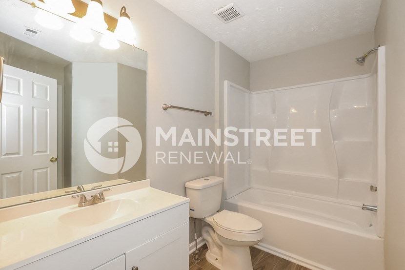 a bathroom with a toilet and a sink and a tub