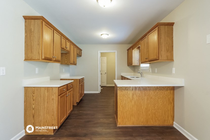 a kitchen with wooden cabinets and white counter tops and a sink