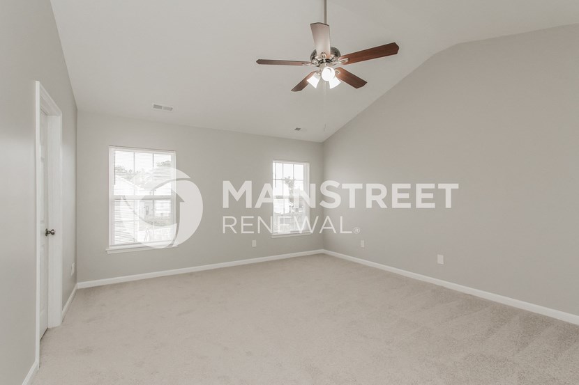 a living room with a ceiling fan and a window