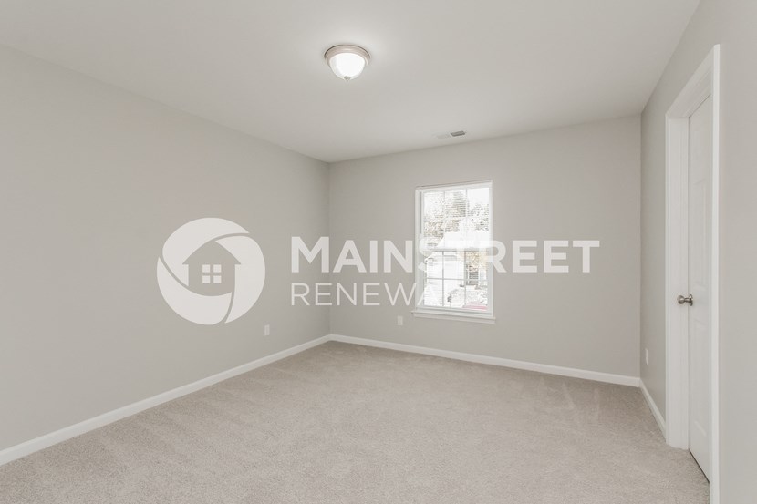 a bedroom with a carpeted floor and a closet