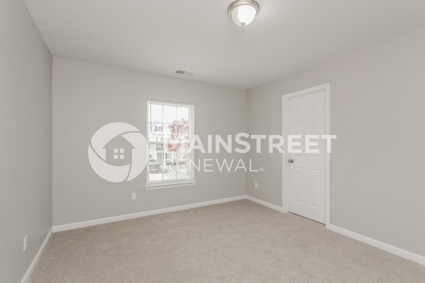 a bedroom with white carpet and a white door
