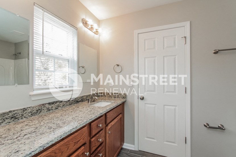 a bathroom with a granite counter top and a white door