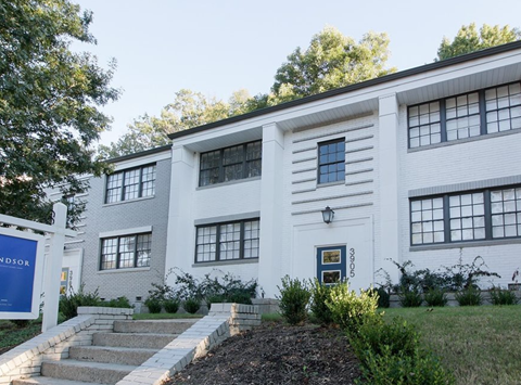 the front of a white building with stairs