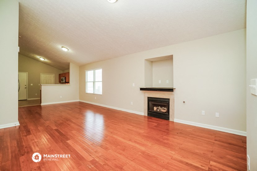 the living room with fireplace and wood flooring