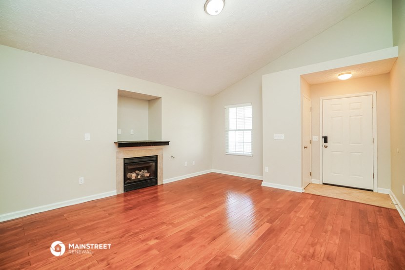 the living room with wood flooring and a fireplace