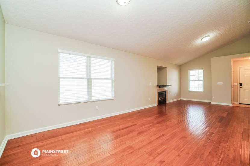 the spacious living room with hardwood floors and a large window