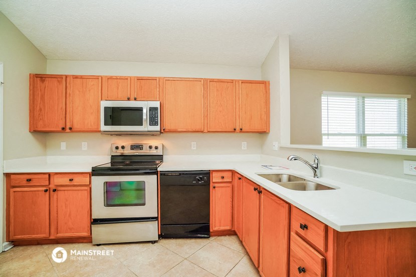 a kitchen with wooden cabinets and appliances and a sink