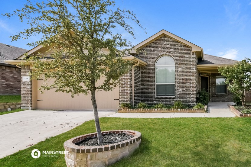 a tree in a yard in front of a house