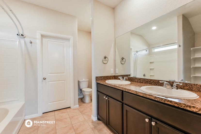 a bathroom with two sinks and a shower and a toilet