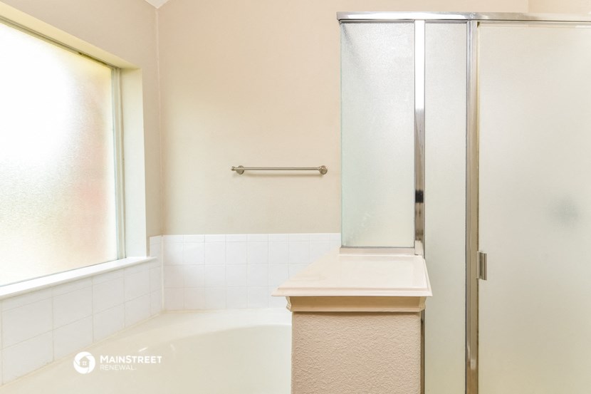 a bathroom with a tub and a shower and a window