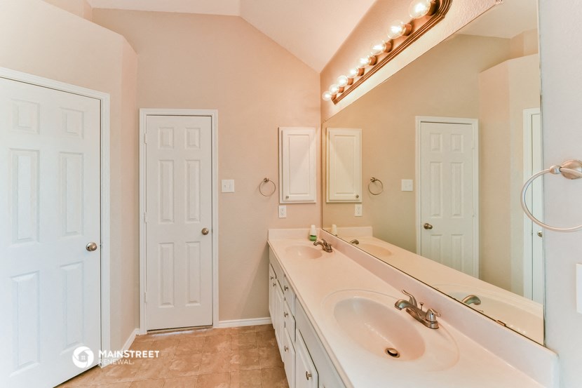 a bathroom with a sink and a mirror and two doors