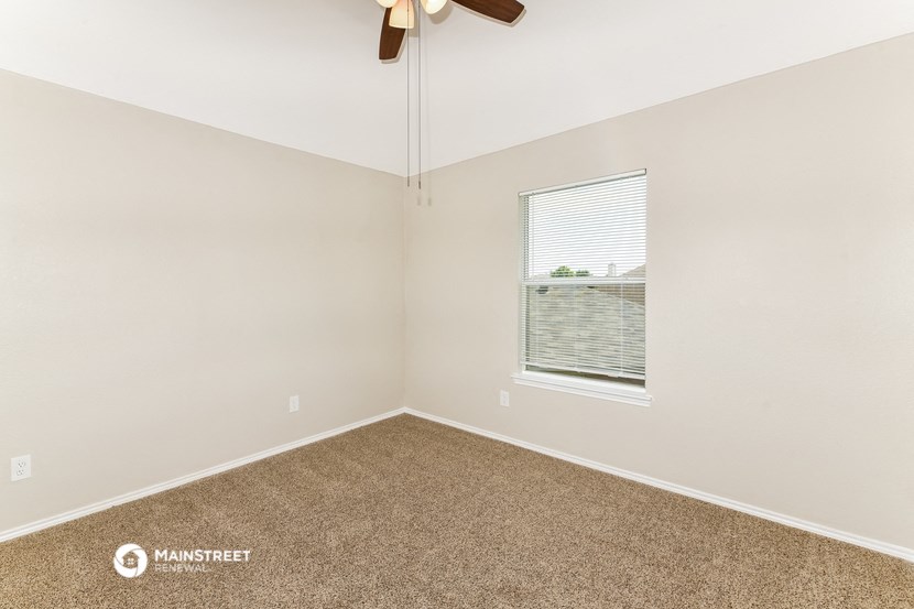 a bedroom with a ceiling fan and a window