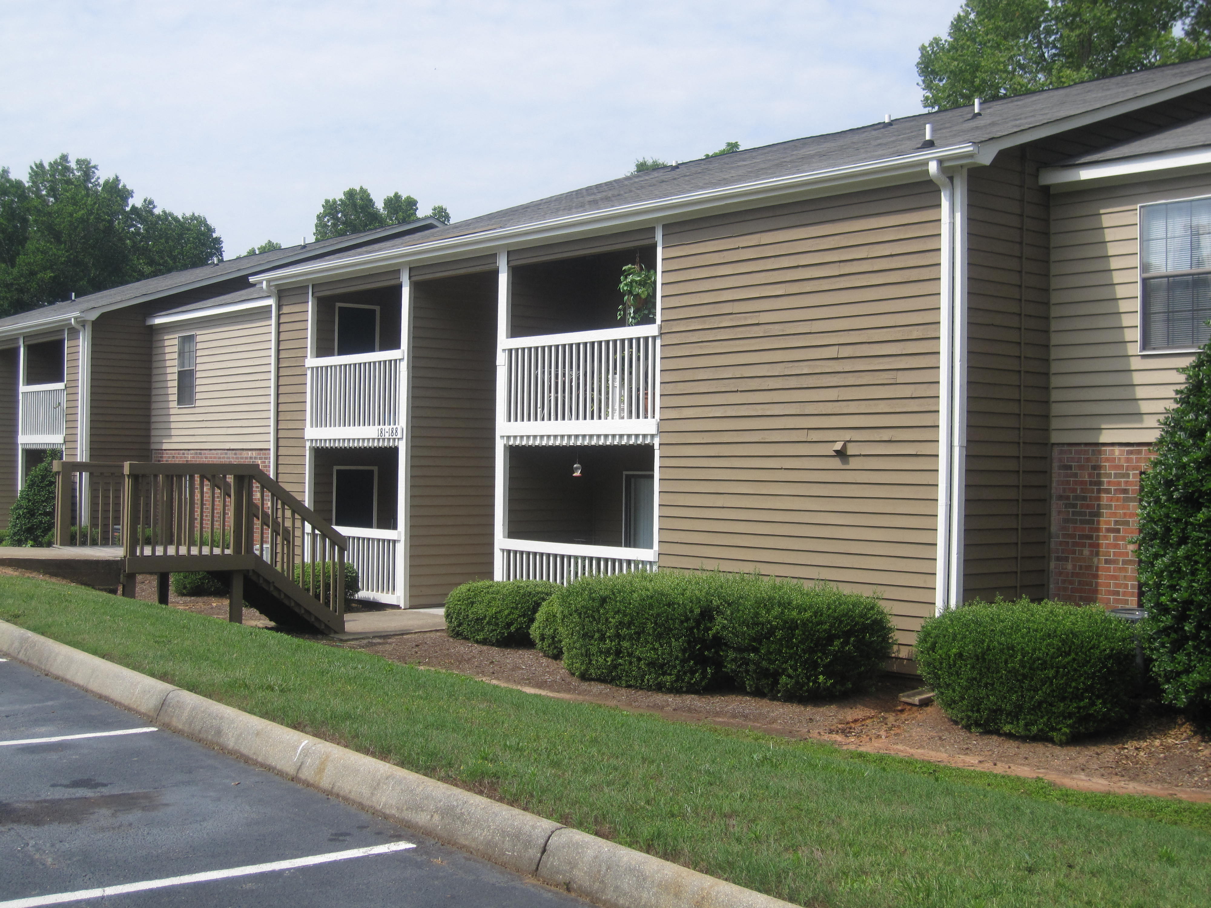 an exterior view of an apartment building with a porch and a deck
