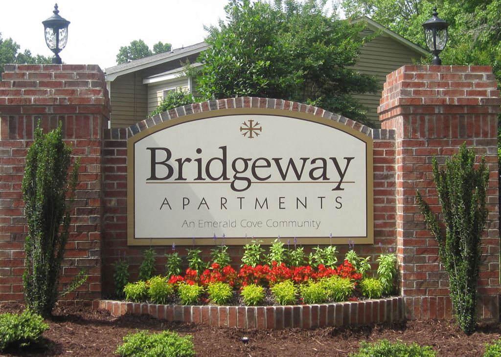 the sign for birdeway apartments in front of a brick wall
