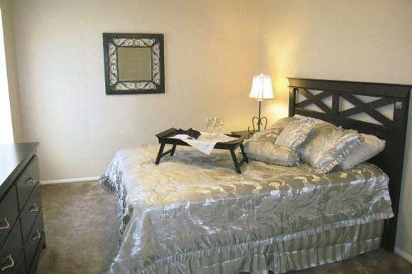 a bedroom with a bed and a table on top of it