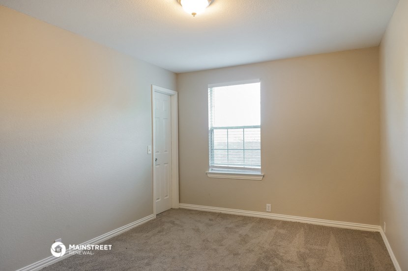 an empty room with a window and a door