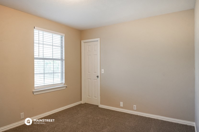 the interior of a bedroom with a door and a window