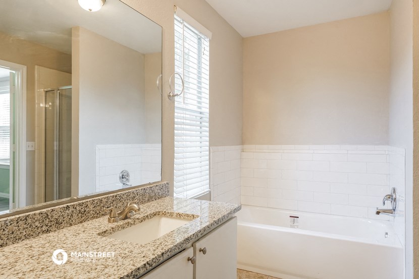 a bathroom with a sink and a tub and a mirror