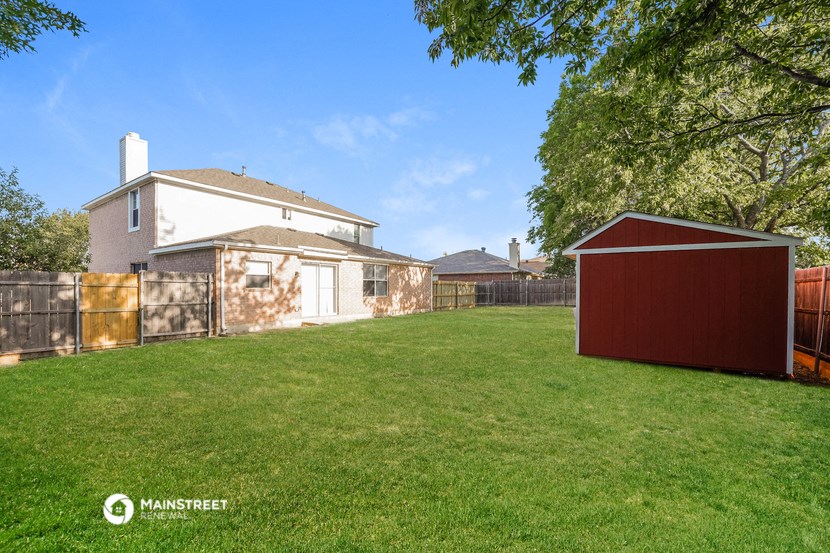 a backyard with a fence and a house and a shed