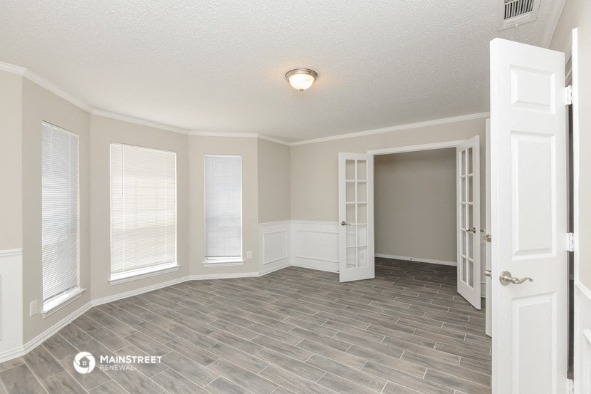 an empty living room with a door to a closet and a window