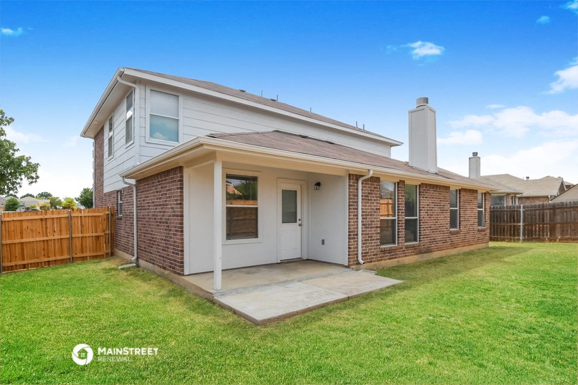 a small brick house with a yard and a porch