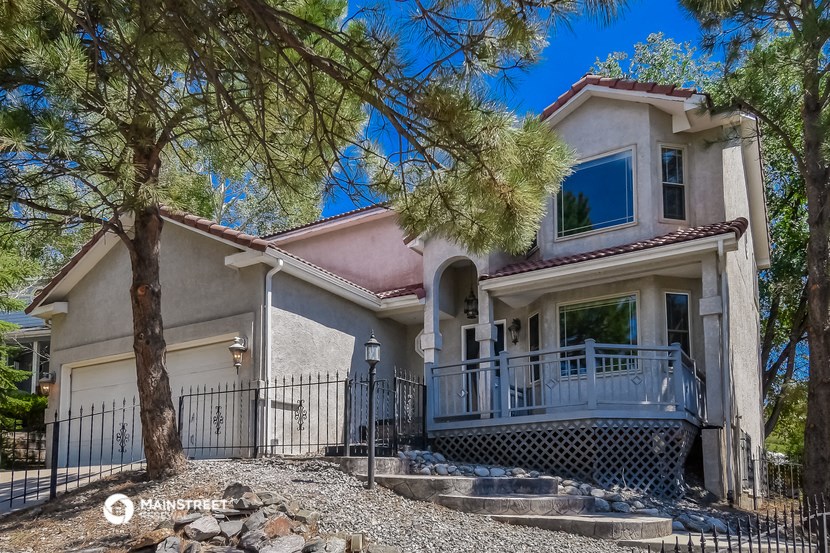 a house with a balcony and a tree in front of it