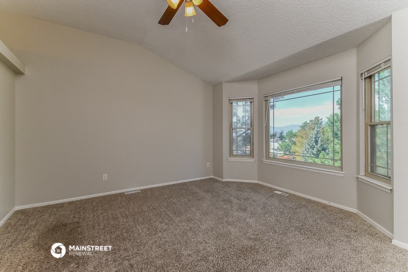 the living room of an empty house with a ceiling fan