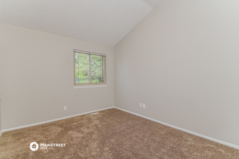 the upstairs bedroom has carpet and a window
