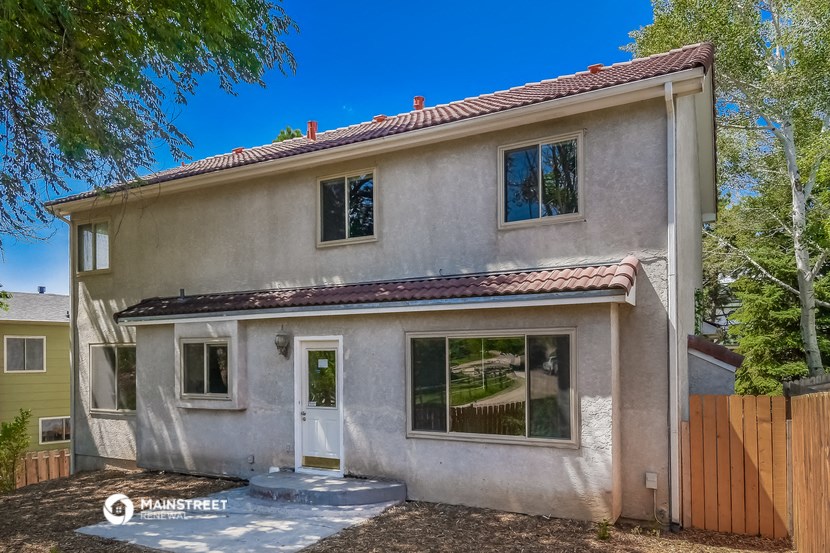 a white house with a red roof and some trees