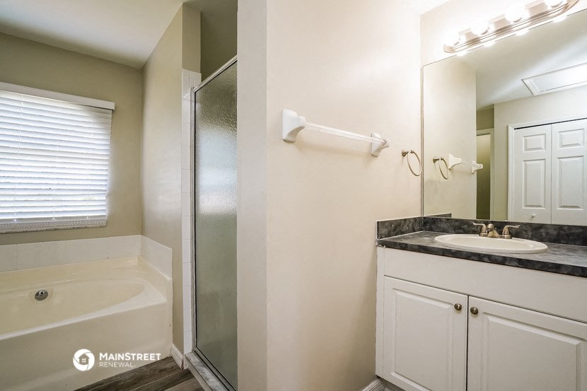 a bathroom with a shower and a sink and a mirror