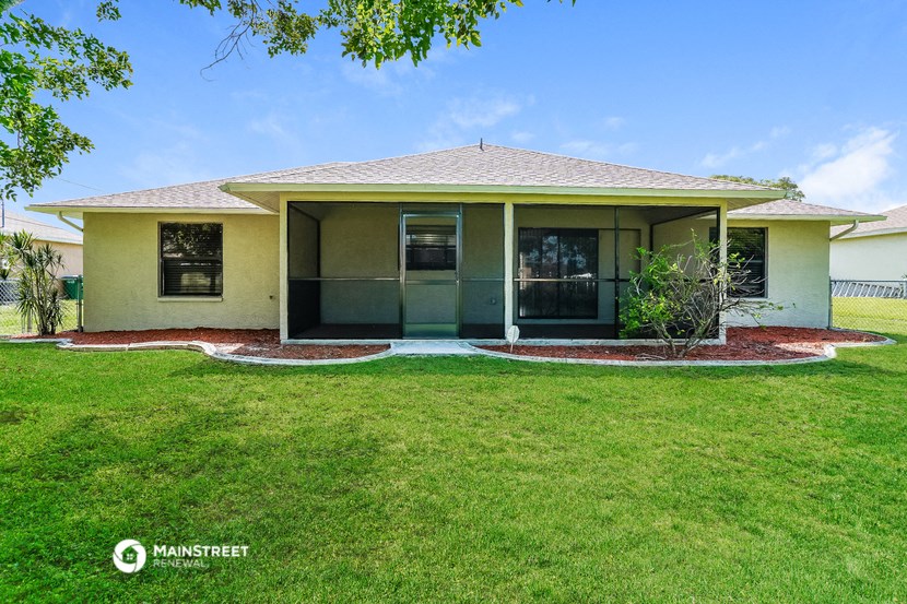 a small yellow house with a lawn and a green yard
