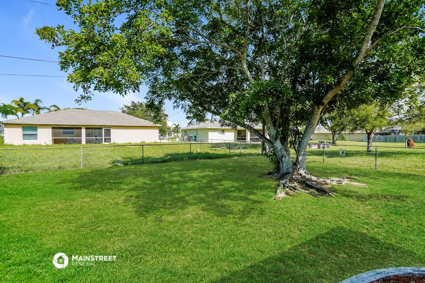 a large yard with a tree and a house in the background