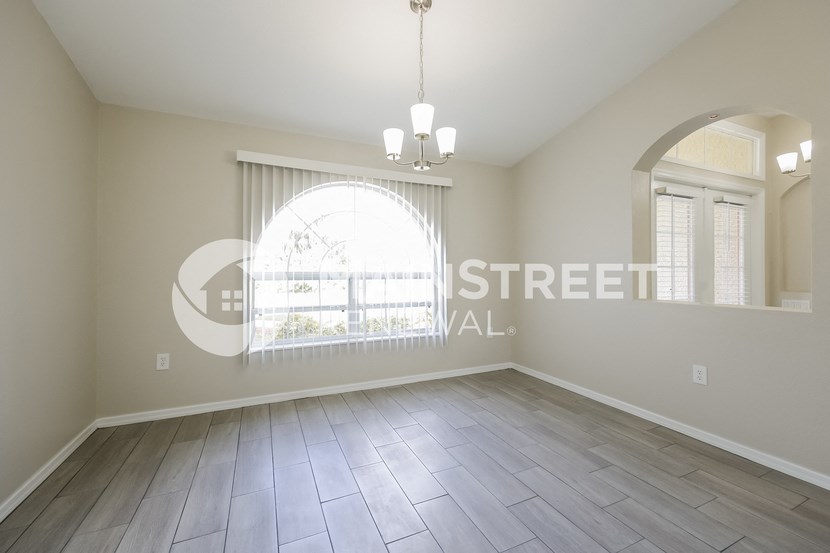 a living room with wood floors and a large window